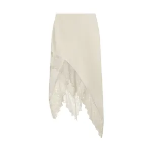 Macro detail view of cream irregular hem skirt featuring delicate white lace patchwork