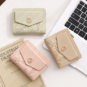Dettaglio di portafogli corti da donna in ecopelle con eleganti motivi a foglia