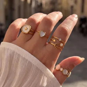 Elegante goldene Edelstahlringe mit Sternen- und Mondmotiven an einer Hand getragen
