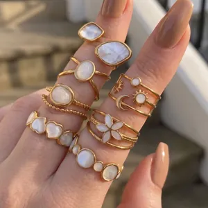 Nahaufnahme von eleganten Edelstahlringen mit weißen Muscheleinlagen an einer Hand gezeigt.