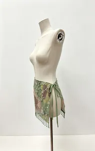 Macro detail of sexy floral print wrap skirt featuring delicate sequins and beaded fringe