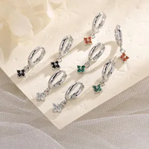 Detailed macro view of silver hoop earrings featuring various colored clover charms