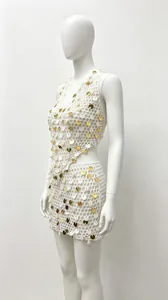 Detailed side view of white crochet top and skirt set featuring gold sequins and shells