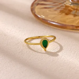 Close-up of a gold-plated titanium steel ring with a pear-shaped green gemstone.