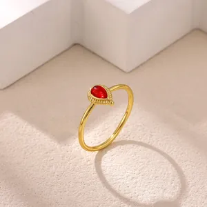 Close-up of vintage gold stainless steel ring with red teardrop gemstone detail