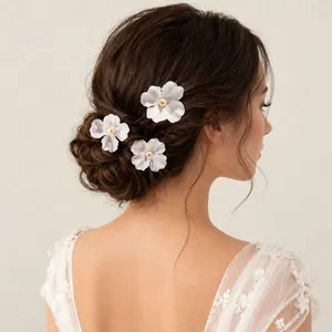 Nahaufnahme von zarten weißen Stoffblumen-Haarnadeln in einer eleganten Brautfrisur