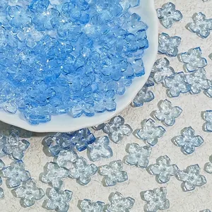 Close-up of 10mm light blue glass four-petal flower beads for DIY jewelry making.