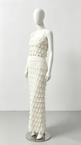 Gedetailleerd overzicht van een elegante witte gebreide tweedelige set met schubtextuur.