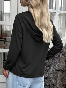 Vista trasera de una sudadera con capucha negra de manga larga para mujer al aire libre