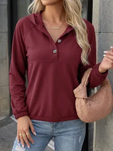 Detalle de una sudadera granate con capucha y botones para mujer en estilo casual.