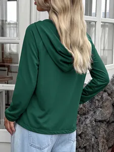 Vista trasera de una sudadera con capucha informal verde oscuro para mujer al aire libre