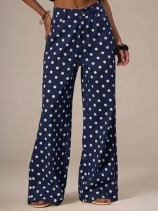 Detail der dunkelblauen weit geschnittenen Jeanshose mit klassischen weißen Punkten