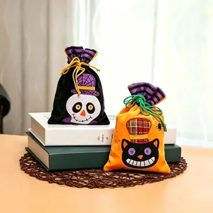 Close-up of Halloween drawstring candy bags with embroidered skull and black cat designs