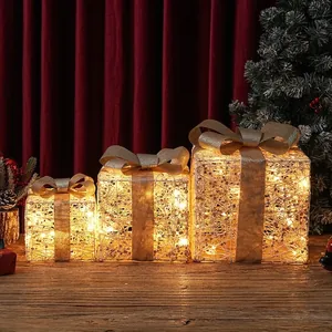 Set aus drei leuchtenden Weihnachtsgeschenkboxen mit warmen LED-Lichtern und Goldbögen