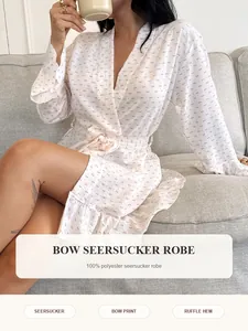 Detail view of white seersucker robe with pink bow print and ruffle hem