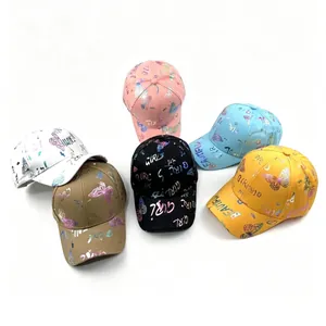 Detalle de gorras de béisbol de colores con mariposas y letras en relieve dorado