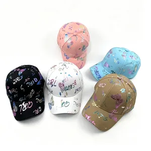 Grupo de cinco gorras de béisbol de colores con mariposas y letras holográficas.