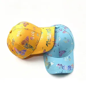 Detalle de primer plano de mariposas y letras doradas en gorras de béisbol de moda