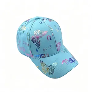 Detalle de una gorra de béisbol azul claro con mariposa brillante y motivos 'girl'