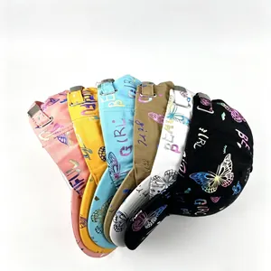 Vista detallada de gorras de béisbol con mariposas de colores y letras doradas.