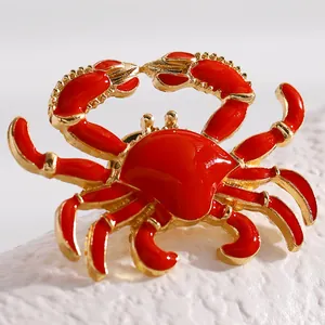 Detailed view of a vibrant red enamel crab brooch with refined golden metal finish and textures