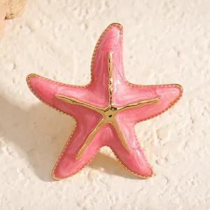 Detaillierte Makroansicht einer rosa perlmuttfarbenen Seesternbrosche mit elegantem Goldrand