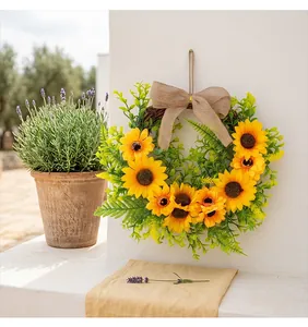Handmade rustic sunflower wreath with burlap bow hanging on a white textured wall
