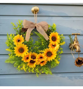 Detailed view of artificial sunflower wreath with a rustic burlap bow decoration.