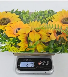 Measurement of bee festival sunflower wreath weight on digital scale showing 210 grams