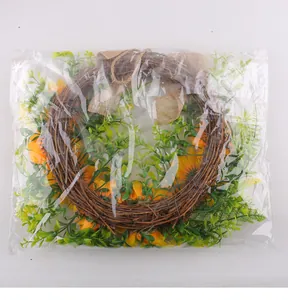 Sunflower wreath with dried branches and green leaves in clear plastic packaging