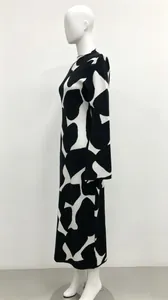 Side view of elegant high-neck knitted dress featuring a bold black and white abstract pattern