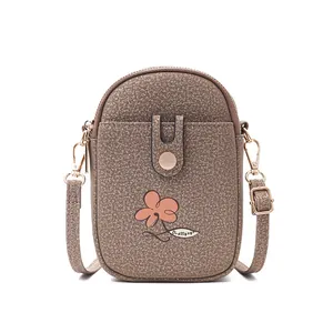 Vue détaillée d'un sac bandoulière marron pour téléphone avec motif floral et sangle réglable.