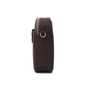 Vue latérale détaillée d'un sac à bandoulière texturé marron foncé avec fermeture éclair dorée
