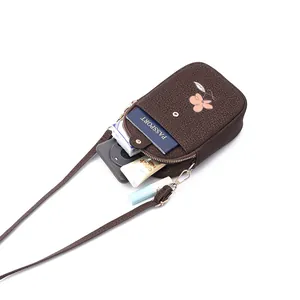Détail d'un sac bandoulière marron pour téléphone avec grande capacité pour passeport.