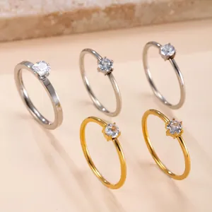 Detailed close-up showing five minimalist six-prong diamond rings in silver and gold finishes