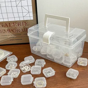 Detailed view of clear mini jewelry boxes and a large storage box on a wooden desk
