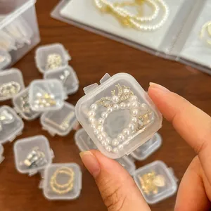 Hand-held view of a mini clear plastic jewelry box showing its portable travel size.