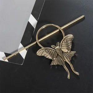 Close-up of vintage gold alloy moth hair stick with gothic butterfly design