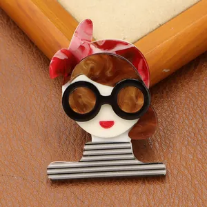 Detailed macro view of an acrylic brooch featuring a girl in a striped shirt