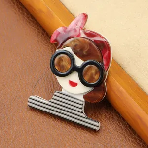 Detailed view of a handmade acrylic brooch featuring a girl in a striped shirt.