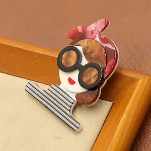 Close-up detail of a fashion acrylic girl brooch wearing sunglasses and stripes
