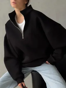 Close-up detail of a black oversized half-zip fleece sweatshirt with a high stand collar