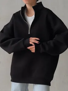 Close-up of women's oversized black half-zip fleece sweatshirt in minimalist urban style.