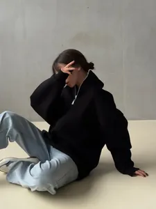 Black oversized half-zip fleece hoodie featuring a minimalist stand collar design