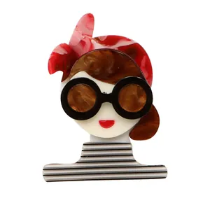 Stylish acrylic girl brooch featuring round sunglasses and a chic striped shirt accessory.