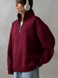 Side view of oversized burgundy half-zip sweatshirt with high collar and warm fleece lining