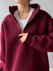 Close-up of oversized burgundy half-zip sweatshirt with high lapel collar detail