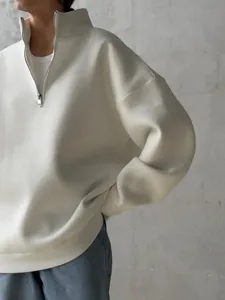 Close-up view of a cream white oversized half-zip sweatshirt with warm fleece lining