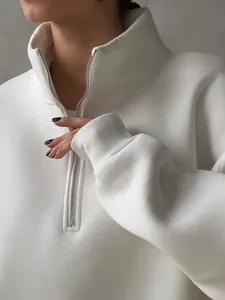 Close-up of white fleece half-zip sweatshirt showing collar and zipper detail