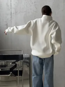 Detailed back view of an oversized white half-zip sweatshirt with a minimalist design.